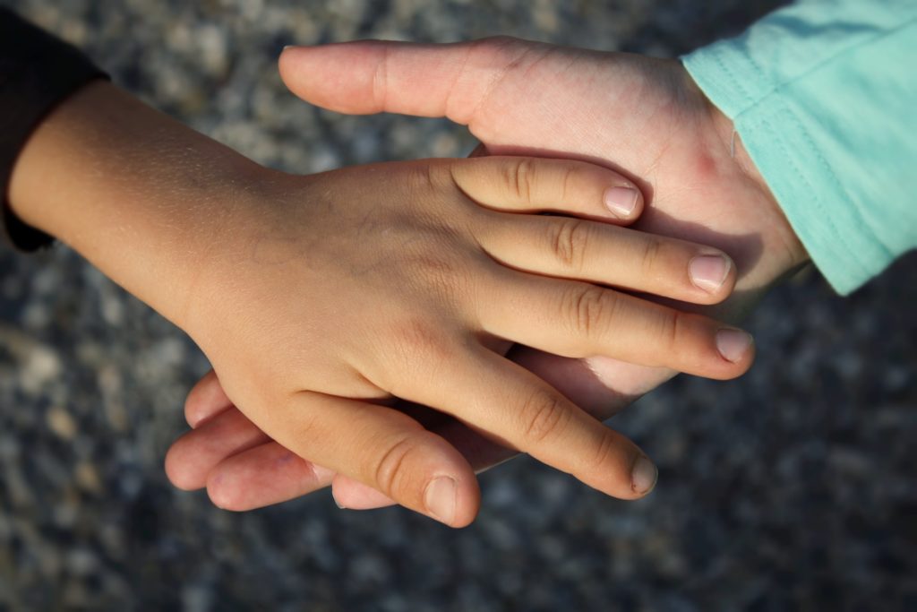 Holding hands and providing support for a child