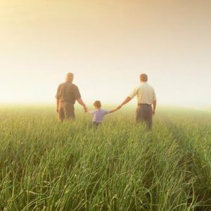 Image of family holding a kids arm side by side